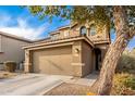 Two-story house with a two-car garage and a tree in front at 18320 N Betty Ct, Maricopa, AZ 85138