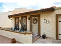 Tan stucco home with a porch, two chairs, and a decorative wreath at 2329 N Recker Rd # 23, Mesa, AZ 85215
