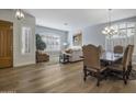 Bright dining room with hardwood floors and a large table, adjacent to living room at 26803 N 45Th Pl, Cave Creek, AZ 85331