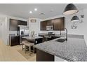 Modern kitchen with dark cabinetry, granite counters, and island at 35208 W Santa Monica Ave, Maricopa, AZ 85138