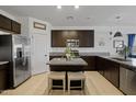 Modern kitchen with dark cabinetry, granite counters, and island at 35208 W Santa Monica Ave, Maricopa, AZ 85138