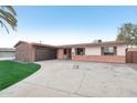 Brick ranch home with a 2-car attached garage and well-manicured lawn at 3609 W Royal Palm Rd, Phoenix, AZ 85051