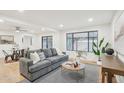Bright living room with gray sofa, hardwood floors, and dining area at 3609 W Royal Palm Rd, Phoenix, AZ 85051