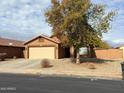 Single-story house with a two-car garage and mature tree at 7766 W Myrtle Ave, Glendale, AZ 85303