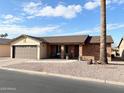 Brick ranch home with brown garage door and desert landscaping at 928 S 79Th Pl, Mesa, AZ 85208