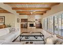 Bright living room with wood beam ceiling, stone fireplace, and sliding glass doors at 1300 Coyote Pass --, Carefree, AZ 85377