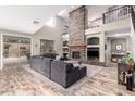 Bright living room boasts a soaring stone fireplace, wood floors, and a comfortable seating arrangement at 3241 E Aris Dr, Gilbert, AZ 85298