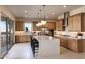 Spacious kitchen with an island, stainless steel appliances, and light wood cabinets at 33608 N Maverick Mountain Trl, San Tan Valley, AZ 85144
