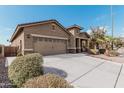 Tan house with a two-car garage and neatly landscaped yard at 514 S 224Th Dr, Buckeye, AZ 85326