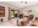 Living room with leather furniture, wooden coffee table, and sliding glass door at 514 S 224Th Dr, Buckeye, AZ 85326