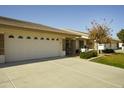 Two-car garage and front yard with landscaping and a for sale sign at 11250 E Kilarea Ave # 245, Mesa, AZ 85209