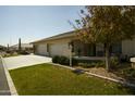 Tan two-car garage with stone accents and a manicured lawn at 11250 E Kilarea Ave # 245, Mesa, AZ 85209