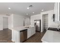 Open kitchen features stainless appliances, quartz counters, white cabinets, island with sink, and walk in pantry at 12362 W Marguerite Ave, Avondale, AZ 85323