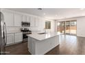 Bright kitchen showcases quartz counters, stainless appliances, white cabinets, and island overlooking the backyard at 12362 W Marguerite Ave, Avondale, AZ 85323