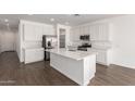 Bright kitchen with white cabinets, quartz countertops, stainless appliances, and an island with sink creates a modern, clean look at 12362 W Marguerite Ave, Avondale, AZ 85323