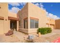 Tan stucco exterior, two-car garage, and landscaped walkway at 1650 S Crismon Rd # 69, Mesa, AZ 85209