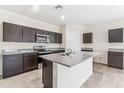 Open kitchen features dark cabinetry, granite countertops, and an island at 1791 W Sombra Ave, Apache Junction, AZ 85120