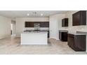 Kitchen boasts dark cabinetry, granite countertops, and an island at 1791 W Sombra Ave, Apache Junction, AZ 85120