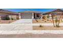 Lovely single-story home with a neutral-toned exterior, a spacious two-car garage, and fresh desert landscaping at 18366 W Poston Dr, Surprise, AZ 85387