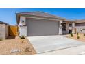 A cozy house featuring a well-maintained two-car garage and tidy front yard with minimalist desert landscaping at 18366 W Poston Dr, Surprise, AZ 85387