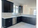 Spacious kitchen with dark cabinetry, stainless steel appliances, and a large island at 18366 W Poston Dr, Surprise, AZ 85387