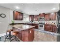 L-shaped kitchen with dark wood cabinets and granite countertops at 4628 W Hasan Dr, Laveen, AZ 85339
