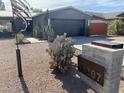 Single story home with gray exterior, landscaped yard, and a modern design at 6307 E Gelding Dr, Scottsdale, AZ 85254