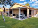 Covered patio with seating area, and grassy backyard at 957 W Lindbergh Ave, Coolidge, AZ 85128