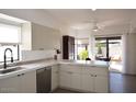 Eat-in kitchen boasts white cabinets, island, and backyard access at 9573 E Dreyfus Pl, Scottsdale, AZ 85260