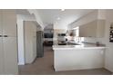 Updated kitchen featuring white shaker cabinets and expansive countertops at 9573 E Dreyfus Pl, Scottsdale, AZ 85260