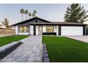 Stunning curb appeal featuring a remodeled home with a paved walkway and lush landscaping at 1743 W Butler Dr, Phoenix, AZ 85021