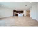 Open-concept living area with tile floors, recessed lighting, and modern stainless-steel appliances at 17603 W Superior Ave, Goodyear, AZ 85338