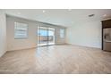 Bright living room with tile floors, recessed lights, and sliding glass door to backyard at 17603 W Superior Ave, Goodyear, AZ 85338