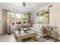 Cozy living room with neutral decor, white couch, large windows with natural light, and ceiling fan at 20100 N 78Th Pl # 1040, Scottsdale, AZ 85255