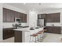 Stylish kitchen featuring a large island with seating, stainless steel appliances, and pendant lighting at 2027 W Sleepy Ranch Rd, Phoenix, AZ 85085