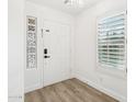 Bright entryway with white door, wood-look floors, and a glass block window at 3376 S 256Th Dr, Buckeye, AZ 85326