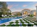 Stunning pool and spa area with a checkerboard lawn and lounge chairs at 9290 E Thompson Peak Pkwy # 422, Scottsdale, AZ 85255