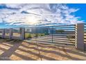 Modern home behind a sleek metal gate, showcasing curb appeal at 10226 N 171St Dr, Waddell, AZ 85355
