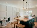 Modern kitchen features a large island with seating, white walls, and dark green cabinetry at 1425 E Desert Cove Ave # 24, Phoenix, AZ 85020