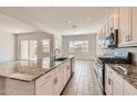 Bright kitchen featuring white cabinets, granite countertops, a large island, and stainless steel appliances at 15041 W Gray Fox Trl, Surprise, AZ 85387