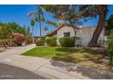 Attractive single-story home with lush greenery, mature trees, and a convenient carport at 15240 N 51St St, Scottsdale, AZ 85254