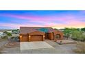 Beautiful desert home exterior with a three car garage and landscaped front yard at 19711 W Georgia Ave, Litchfield Park, AZ 85340