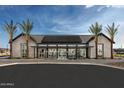 Community center with solar panels, tall palm trees, and ample parking at 23031 E Starflower Dr, Queen Creek, AZ 85142