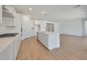 Open concept kitchen with stainless appliances, quartz countertops, large island, and sleek white cabinets at 23048 E Watford Dr, Queen Creek, AZ 85142