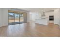 Bright and airy living room with wood-look tile flooring, large sliding glass doors, and seamless kitchen access at 23048 E Watford Dr, Queen Creek, AZ 85142