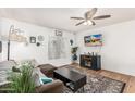 Bright living room with wood floors, comfy couch, and a large TV at 2548 W Monte Cristo Ave, Phoenix, AZ 85023