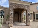 Elegant entryway with arched stone detail and wood door at 3804 E Camelback Rd, Phoenix, AZ 85018