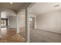 Open-concept living space with archways, tile floors, and carpet at 42374 W Avella Dr, Maricopa, AZ 85138