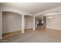 Open living area with tiled flooring, carpet, and arched doorways at 42374 W Avella Dr, Maricopa, AZ 85138