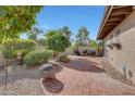 Well-maintained backyard with brick patio, gravel accents, and lush landscaping at 9443 E Riviera Dr, Scottsdale, AZ 85260